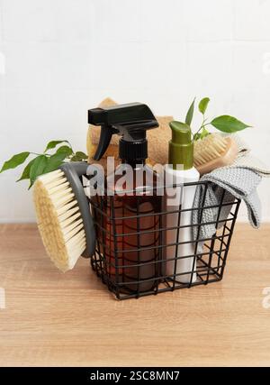 I prodotti per la pulizia, tra cui flacone spray, spugne, spazzole e liquidi per la pulizia, sono disposti in un cestello di metallo per favorire la pulizia ecocompatibile Foto Stock