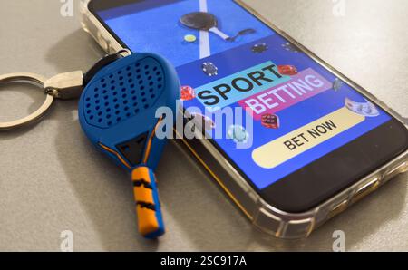 Sito Web di scommesse sportive sullo schermo di un telefono cellulare, racchetta del padel Foto Stock