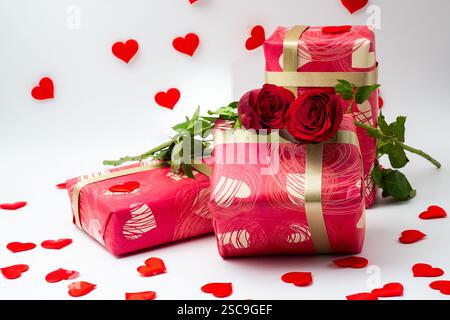 Confezioni regalo confezionate con rose isolate su sfondo bianco e cuori piccoli Foto Stock