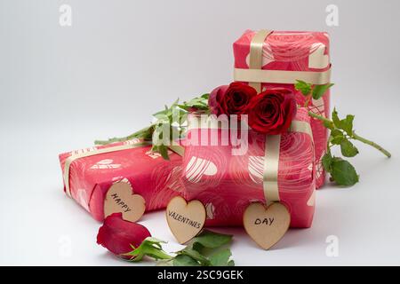 Confezioni regalo confezionate con rose isolate su sfondo bianco e un messaggio Foto Stock