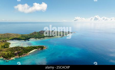 L'isola tranquilla si estende nel vasto mare turchese, con onde dolci e un orizzonte sereno. Curieuse, Seychelles. Foto Stock