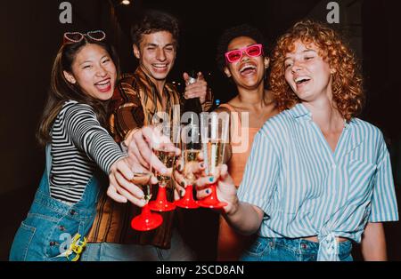 Amici che escono la sera e fanno festa. I giovani si incontrano all'aperto nel fine settimana e festeggiano insieme. Foto Stock