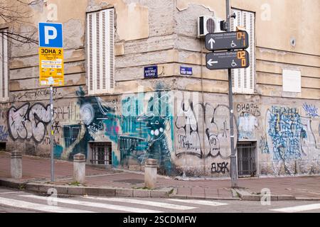 Belgrado, Serbia - 27 gennaio 2025: Angolo via Dorcol con graffiti sul vecchio edificio residenziale e cartelli per il parcheggio Foto Stock