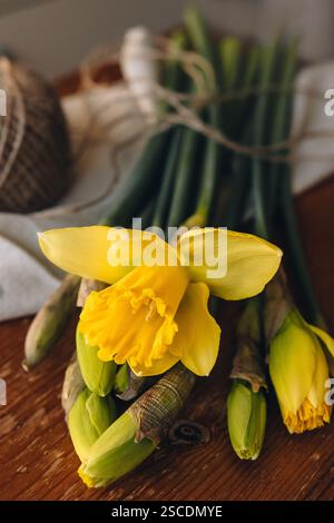 Narcisi su un tavolo di legno in una giornata di sole all'interno. Narciso giallo o fiori di narciso. Sfondo fiori primaverili. Scheda molla con spazio per il testo. Foto Stock