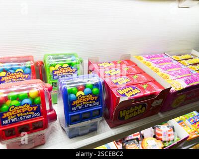 Kiev, Ucraina - 5 febbraio 2025: Varie caramelle, confezioni di gomma e giocattoli vivaci presentati su uno scaffale ben illuminato. Foto Stock