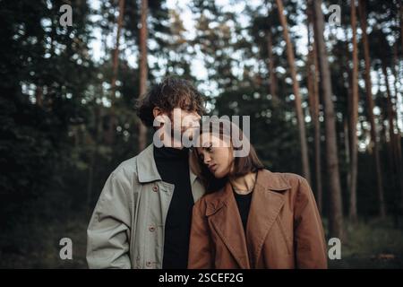 Una serena scena di una coppia che abbraccia in una foresta con emozioni espressive Foto Stock