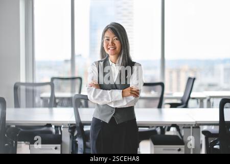 Donna d'affari asiatica felice di mezza età leader in carica, ritratto. Foto Stock
