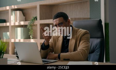 Uomo afro-americano uomo d'affari uomo uomo uomo uomo uomo uomo uomo uomo d'affari uomo uomo uomo che lavora laptop in ufficio progetto di business online serio imprenditore insoddisfatto che guarda le vibrazioni della fotocamera Foto Stock