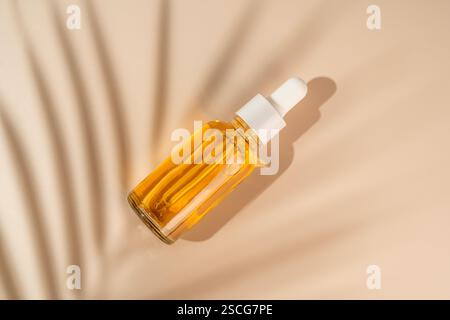 Flacone contagocce arancione con siero o olio di vitamina C. Prodotto per la cura del viso e dei capelli di bellezza. Marketing linea di produzione Foto Stock