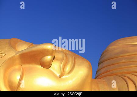 Buddha dorato sdraiato al Wat Phranon Laem Pho (statua del Buddha sdraiato) famose attrazioni pubbliche di Koh Yo, Songkhla, Thailandia Foto Stock