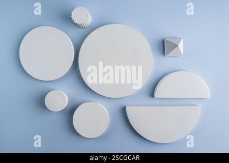 Podi geometrici bianchi costituiti da cerchi di cemento di forme e piramidi diverse. Podi per la presentazione dei prodotti. Foto Stock