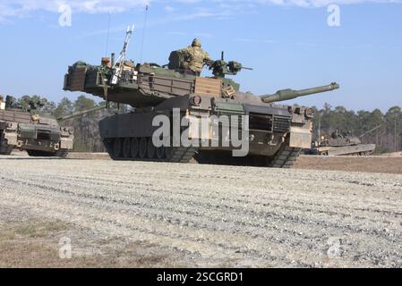 I soldati dell'esercito degli Stati Uniti assegnati al 2nd Battalion, 69th Armor Regiment, 2nd Armored Brigade Combat Team, 3rd Infantry Division, avanzano il loro carro in pos Foto Stock