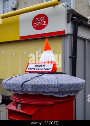 Cassetta postale Royal mail con copertura a maglia con cono stradale e cartello in costruzione, Hackleton, Northamptonshire, Regno Unito Foto Stock