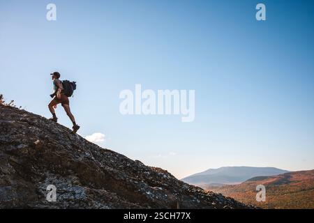 Una sana escursionista femminile cammina in montagna nel Maine durante l'autunno Foto Stock