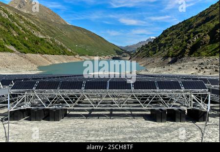 I pannelli solari della prima centrale solare alpina galleggiante si trovano con la bassa marea sulla riva del bacino idrico del Lac des Toules, Vallese, Svizzera Foto Stock