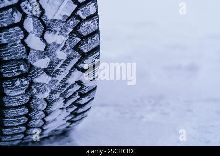 Un dettaglio ravvicinato di uno pneumatico coperto di neve, catturato nel paesaggio invernale della Lapponia svedese. L'immagine evidenzia la trama e il battistrada Foto Stock