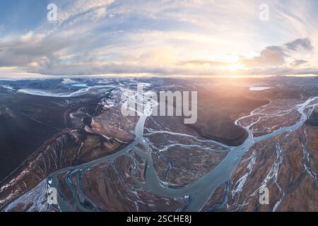 Vista aerea degli altopiani islandesi, che mostra intricate reti fluviali che si intrecciano tra terreni accidentati al tramonto. Un esempio mozzafiato della natura è A. Foto Stock