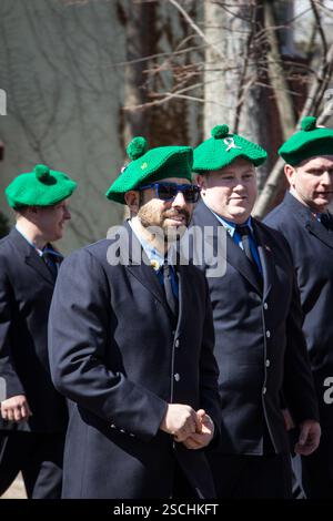 Uomini in berretti verdi, abiti scuri, probabilmente in una parata del giorno di San Patrizio. Foto Stock
