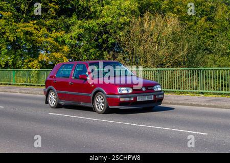 Anni '1997 90 Novanta Red VW Golf GTi che attraversa il ponte autostradale a Manchester, Regno Unito Foto Stock