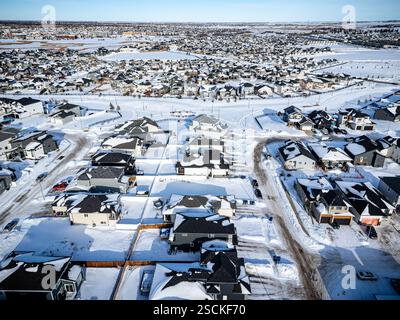 Città innevata con case e auto. Le case sono tutte bianche e la neve copre il terreno Foto Stock