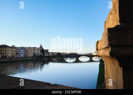 Interessante vista di uno dei ponti più antichi della città di Firenze. E' l'alba e in primo piano c'e' un elemento architettonico di pietra tha Foto Stock