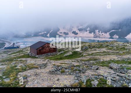 Bivacco San Camillo e la diga del Lago della Rossa con iceberg nelle Alpi Graie in Italia durante la sera estiva Foto Stock