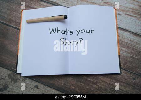 Un quaderno vuoto che pone la domanda sui racconti personali, con una penna appoggiata sulle pagine aperte. Foto Stock