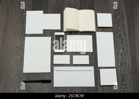 Disposizione dell'area di lavoro con cancelleria vuota, smartphone e notebook su un tavolo in legno Foto Stock