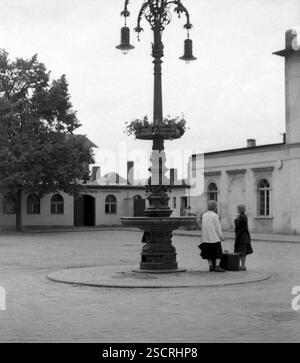 Due donne anziane stanno con le valigie accanto a una lanterna sulla piazza di fronte alla stazione di Fürstenwalde. [traduzione automatizzata] Foto Stock