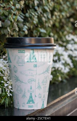 Elegante tazza da caffè che riposa vicino al verde vivace e ai fiori in un ambiente urbano Foto Stock