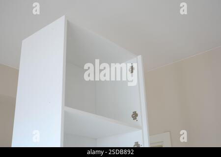 Armadietto bianco con ripiani vuoti in una stanza luminosa Foto Stock