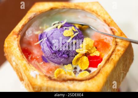 L'alone di Halo-halo, condito con una pallina di gelato all'uovo e servito all'interno di una noce di cocco, è una delizia popolare nelle Filippine Foto Stock