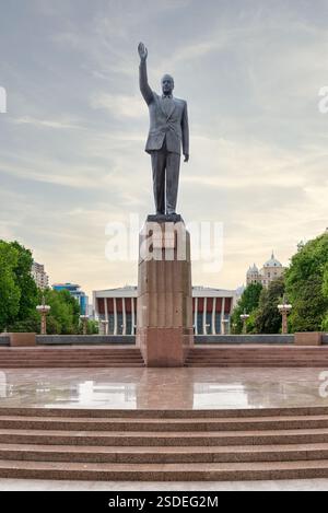 Baku, Azerbaigian - 5 maggio 2024: Statua in ottone di Heydar Aliyev, dedicata all'ex presidente azero, in piazza Heydar Aliyev, di fronte a un palazzo che porta il nome del presidente Foto Stock