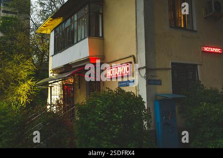 Almaty, Kazakistan - 29 aprile 2023: Vecchia casa a due piani con cartello notarile al primo piano, vista serale. Foto Stock