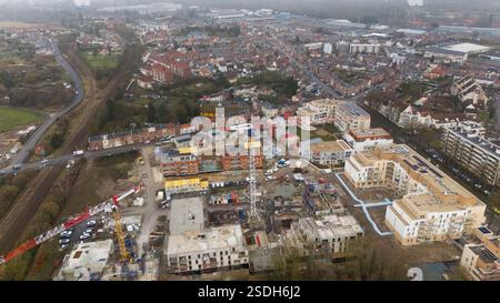 Vista aerea di un cantiere ad Amiens, Francia, con gru, nuovi edifici residenziali e un quartiere adiacente. Un'istantanea della crescita e dello sviluppo urbano. Foto Stock