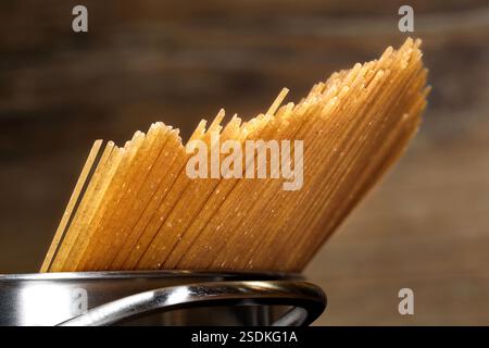 primo piano di spaghetti di grano intero non cotti in pentola, sana alternativa ricca di fibre alla pasta classica Foto Stock