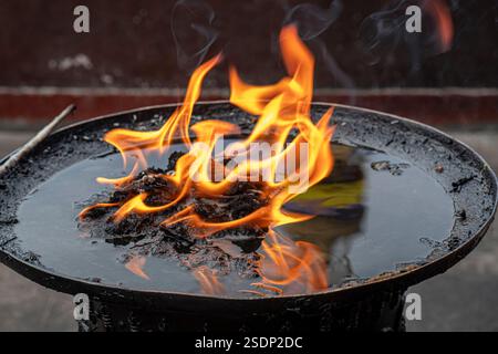 Fiamme della candela che danzano di fronte al Boudhanath Stupa a Kathmandu, Nepal Foto Stock
