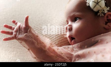 Cute Newborn Baby Girl sdraiata sul letto si è avvicinata Foto Stock