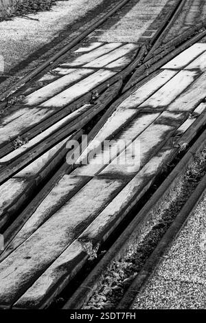 Primo piano in bianco e nero di binari ferroviari e traversine in legno Foto Stock
