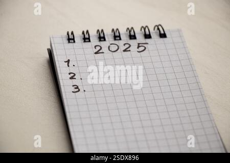 il 2025 e il 123 sono scritti in un quaderno che si trova sul tavolo, i piani per il nuovo anno, scrivere i piani Foto Stock