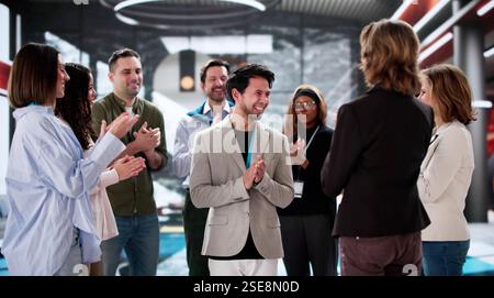 Celebrare il successo: Team di uffici diversificati che si congratulano con il dipendente per i risultati professionali ottenuti. Foto Stock