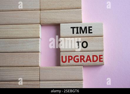 Simbolo tempo di aggiornamento. Parole concettuali Time to Upgrade su blocchi di legno. Bellissimo sfondo rosa. Business e Time to Upgrade. Copia spazio. Foto Stock