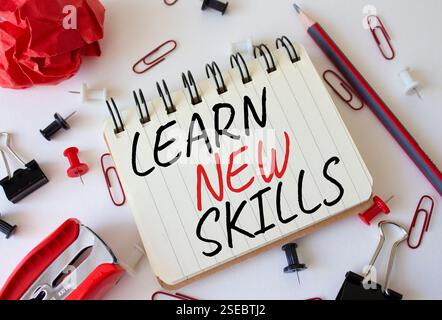Simbolo di nuove competenze. Parole concettuali Impara nuove competenze su un notebook bianco. Splendido sfondo bianco. Business e apprendimento di nuovi concetti di competenze. Servizio fotocopie Foto Stock