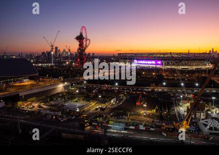 Il sole tramonta dietro il London Stadium e i lati dei lavori nel parco olimpico post-giochi di Stratford, East London. Foto Stock