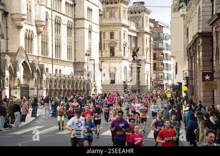 Corridori in una maratona vicino alla Royal Courts of Justice di Londra. Molti partecipanti, probabilmente una gara su larga scala, sono visti per strada. Foto Stock