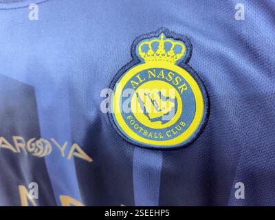 Logo della squadra di calcio al nassr su tessuto in Jersey blu con design ricamato. Foto Stock