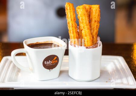 Churros con cioccolata calda spessa fatta con tablea Cebu serviti su un tavolo di legno al Tablea Cafe Foto Stock