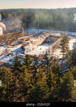 Cantiere sulla neve, circondato da alberi e gru, sotto un cielo limpido, nuova stazione dei vigili del fuoco, Oberhaugsett, quartiere di Calw, Germ Foto Stock