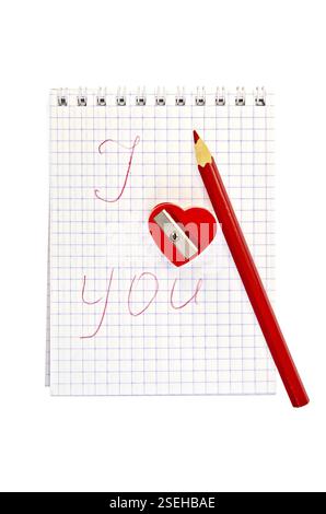 Affilatrice a forma di cuore rosso con una matita e un quaderno etichettato isolato su sfondo bianco Foto Stock