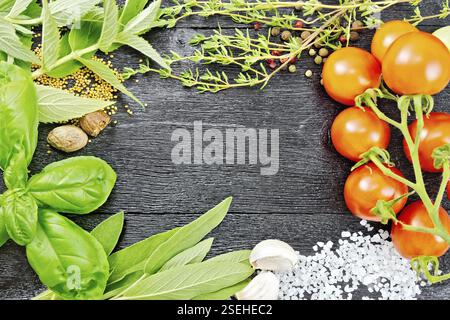 Telaio del salato, foglie di salvia, il basilico e il timo, sale, noce moscata e aglio, semi di senape, i piselli e i pomodori sullo sfondo delle tavole di legno Foto Stock